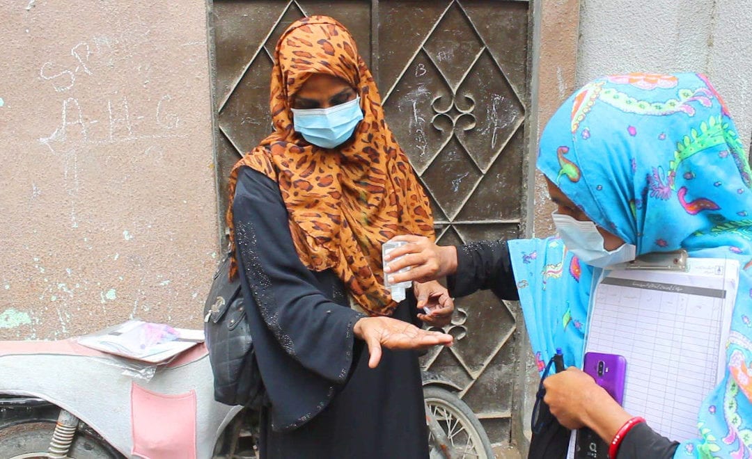 Vaccinator w/ sanitizer as Covid precaution in Pakistan